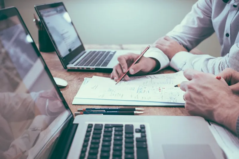 Two business owners going through their financial figures on a laptop