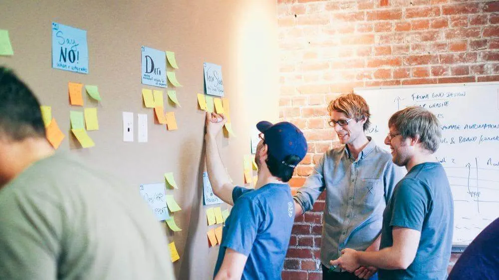 Three Invoice Office developers planning the next release at a wall of sticky notes